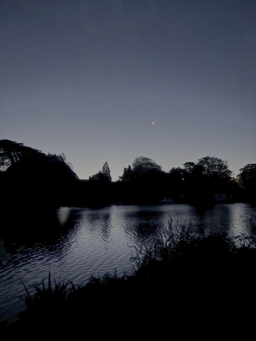 The Thames at dawn near Cookham, a crescent moon above the trees